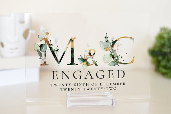 This elegant acrylic plaque is the perfect personalised gift for an engaged couple. Featuring the first letters of the couple&#39;s names surrounded by a beautiful floral design, it&#39;s a thoughtful and stylish way to celebrate their engagement.