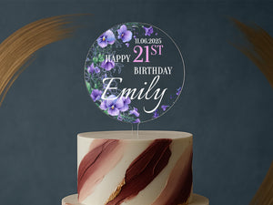 a white and pink cake with purple flowers on top