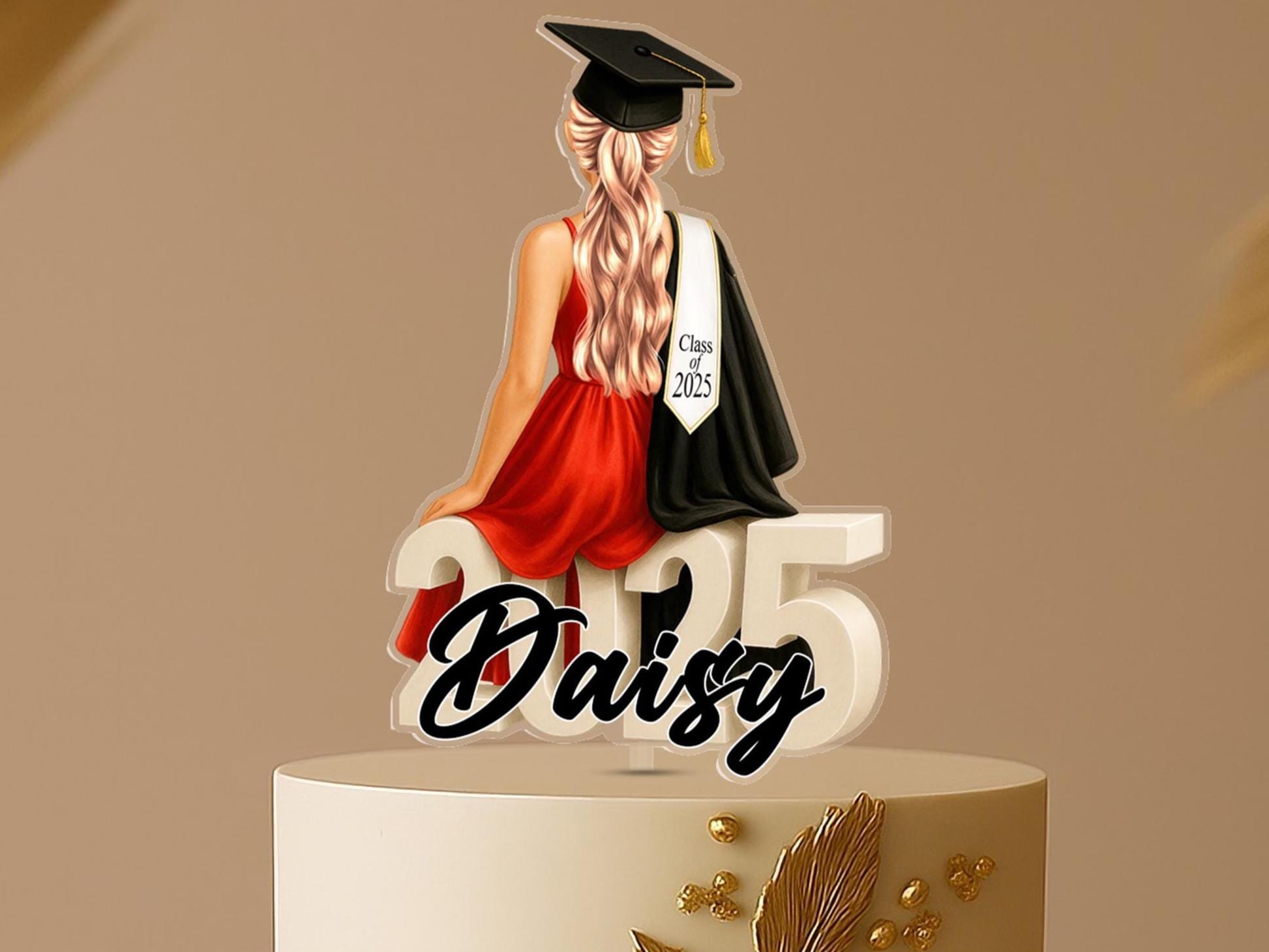 Personalised graduation cake topper featuring a female graduate in a red dress with long blonde hair, sitting on "2025" and holding a diploma, custom name Daisy in script.