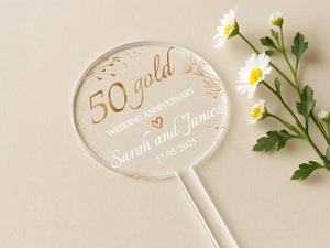 a white and gold wedding fan next to some daisies