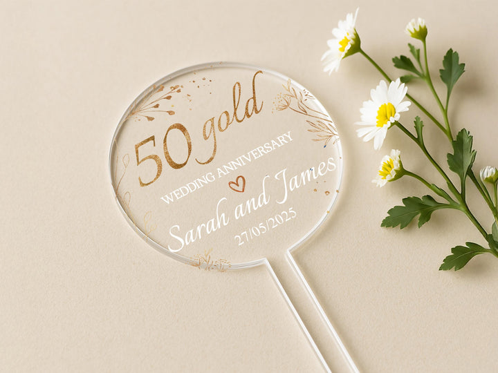a white and gold wedding fan next to some daisies
