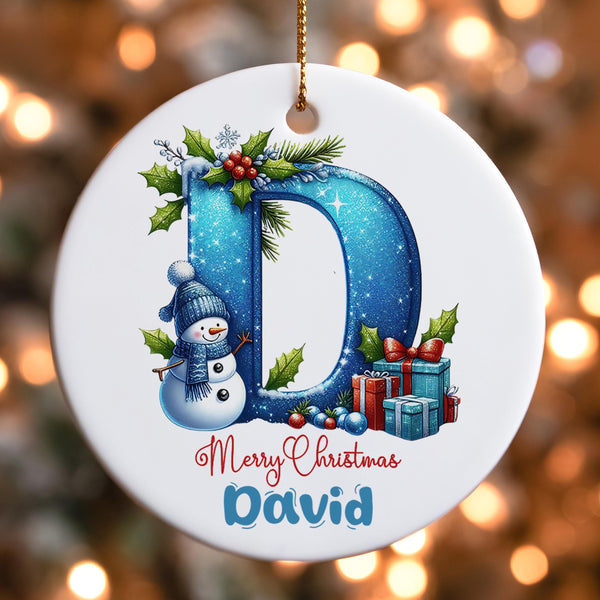 Personalised Christmas ornament featuring decorative letter D with winter snowman, holly, presents and custom name David held in hands showing scale and detail