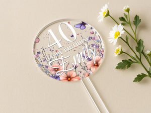 a birthday cake topper with flowers and butterflies
