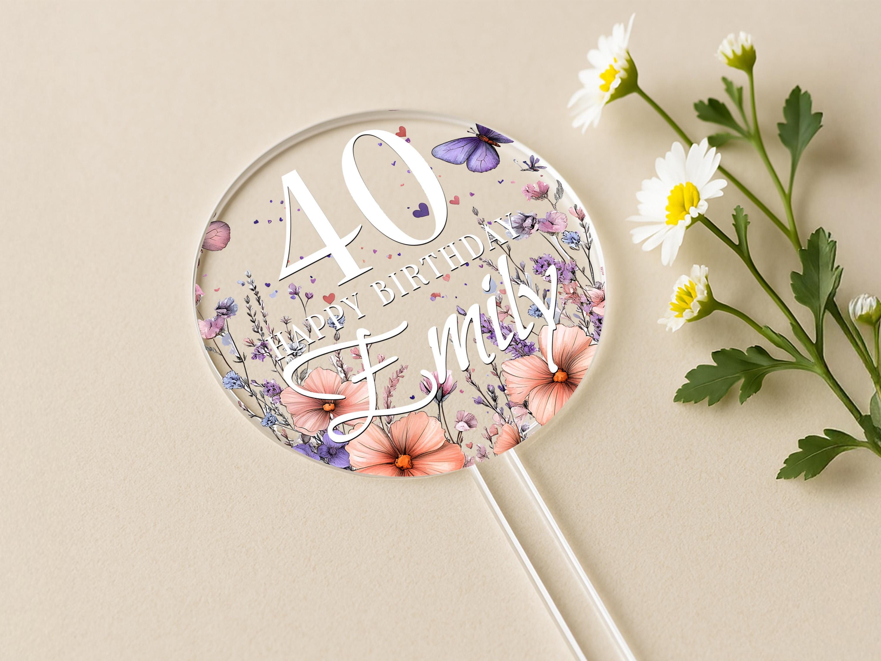 a birthday cake topper with flowers and butterflies