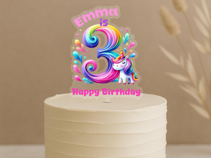 Custom rainbow swirl unicorn birthday cake topper featuring elaborate number 3 with spiral rainbow design, unicorn character and personalised name Emma