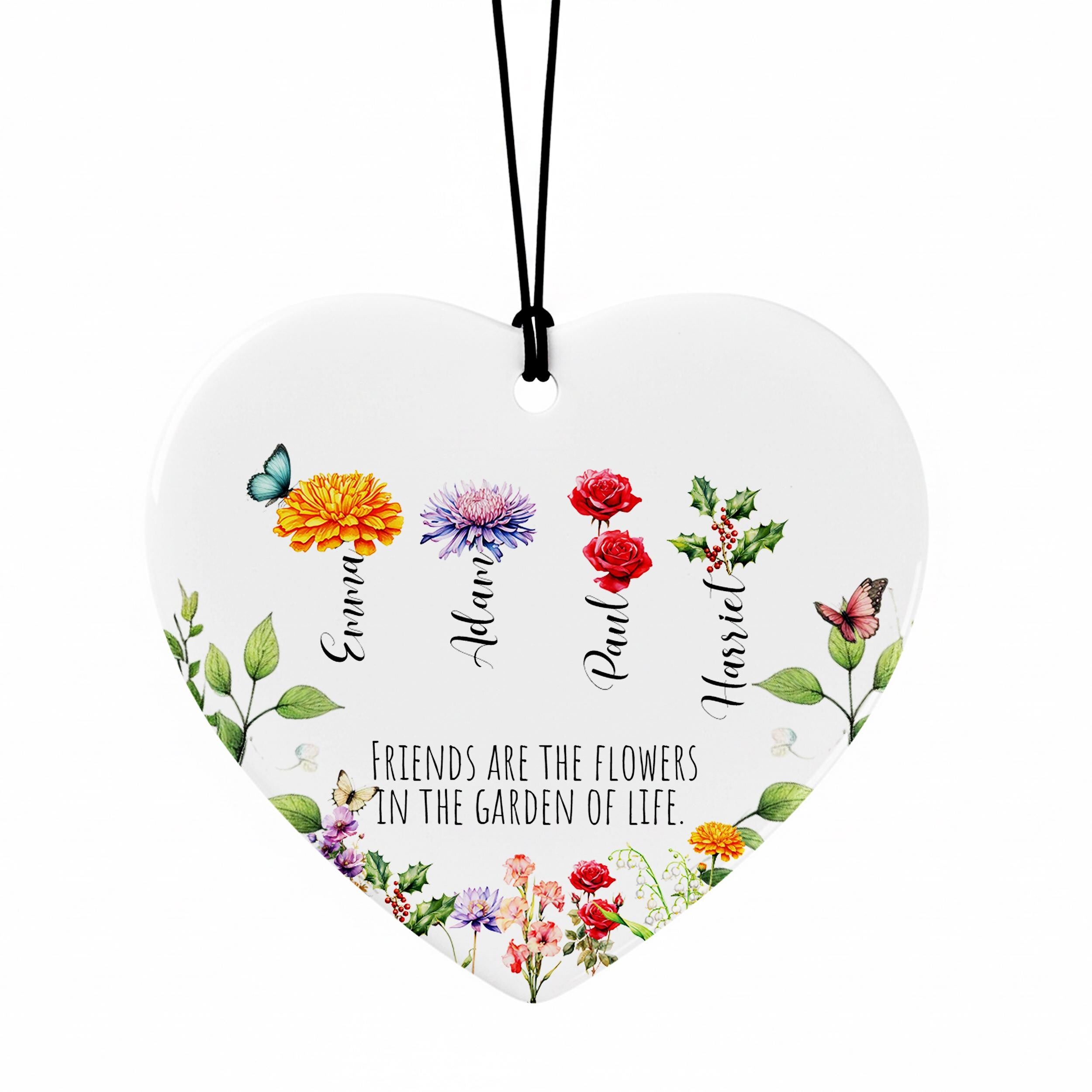 A heart-shaped ornament with a floral design and the text "Friends are the flowers in the garden of life" printed on it.