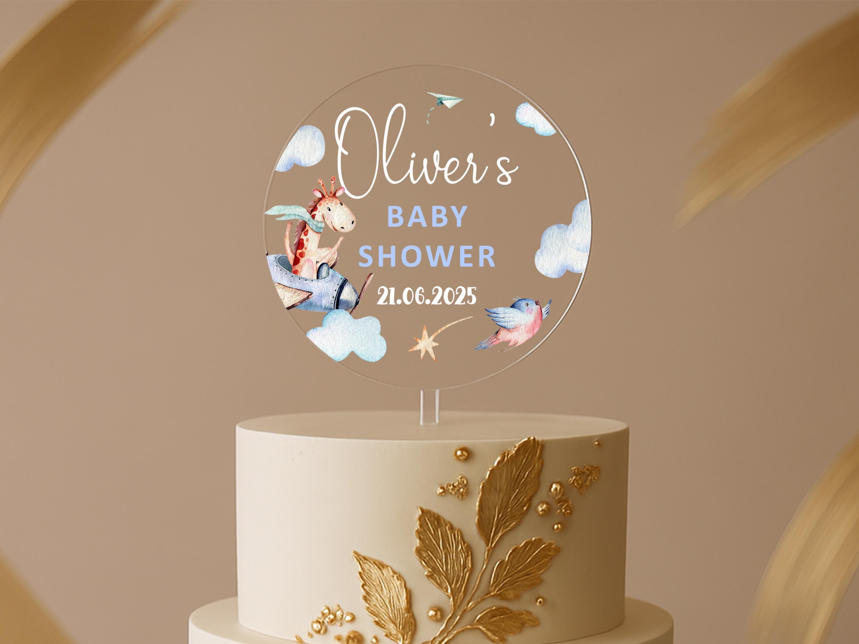 a white and gold cake with a baby's name on top