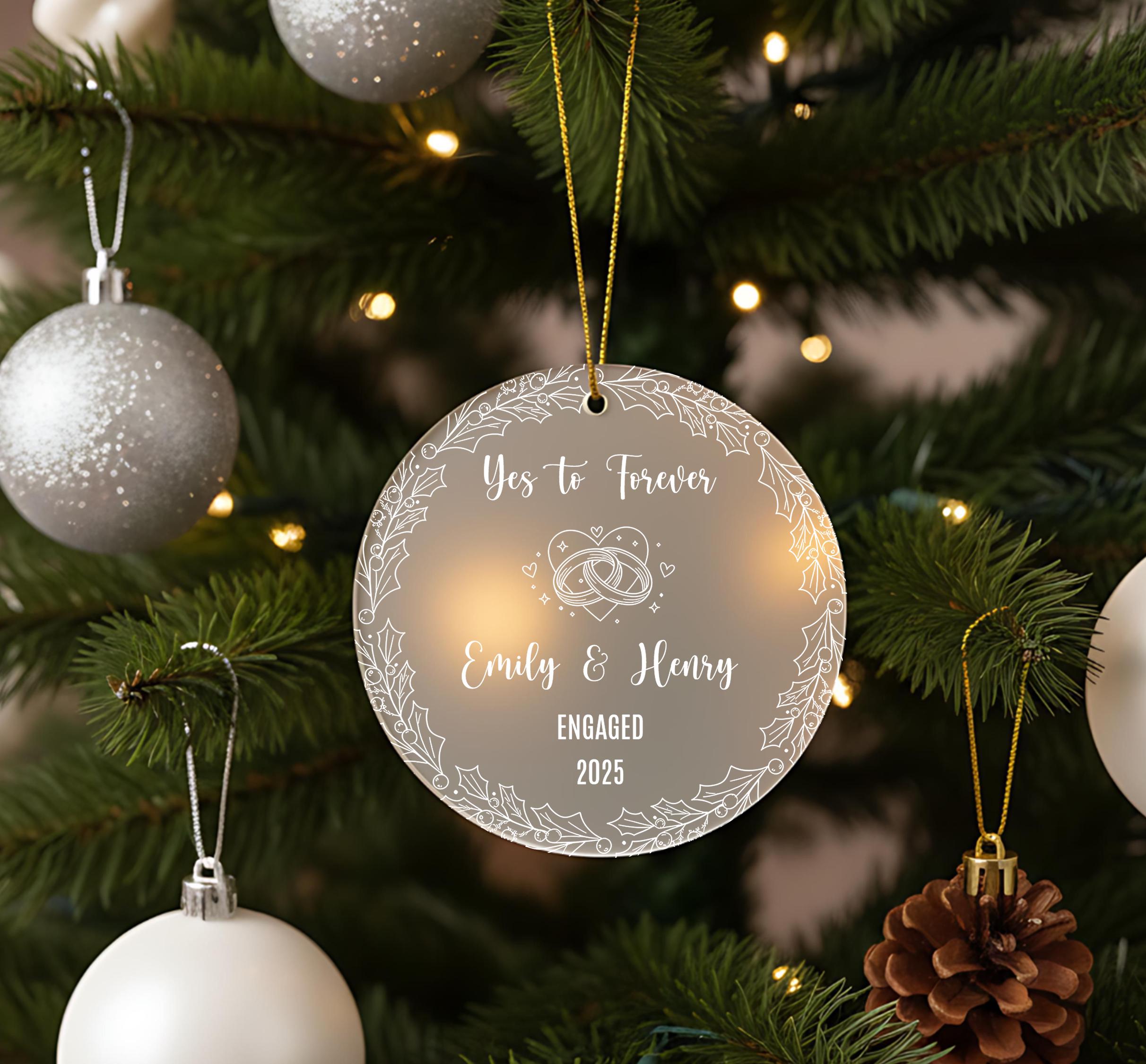 A clear ornament with a message hangs on a Christmas tree, surrounded by ornaments and lights.