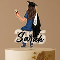 Personalised nurse graduation cake topper with a female graduate in scrubs and gown, sitting on “2025,” for Class of 2025, custom acrylic decoration.