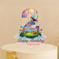 A birthday cake topper with a fairy and a number 2, along with the text "Happy Birthday Hannah".