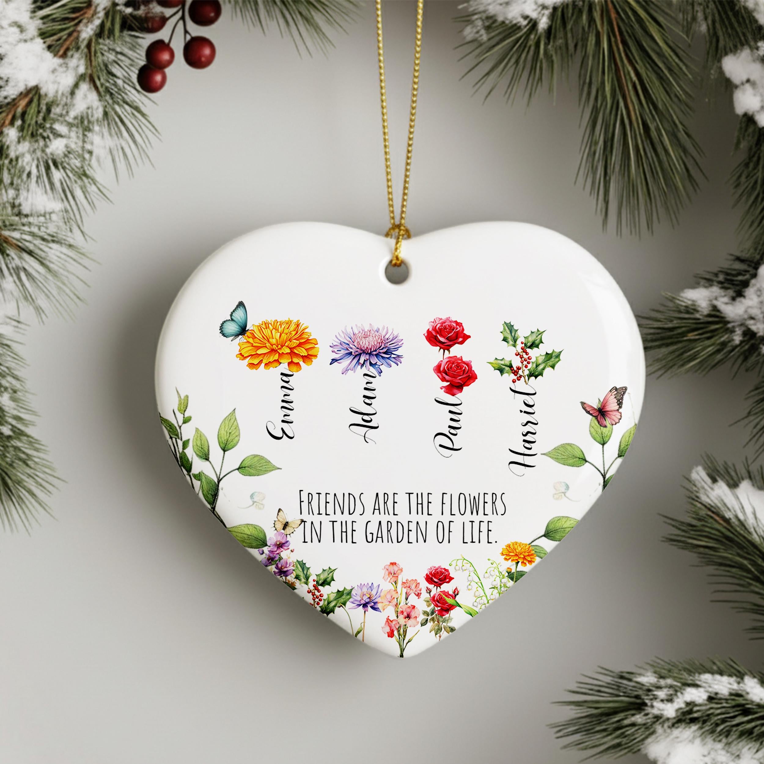 A heart-shaped ornament with a floral design and the names of four friends, each represented by a different flower. The ornament is hanging from a string, and there is a text message below it that reads "Friends are the flowers in the garden of life".