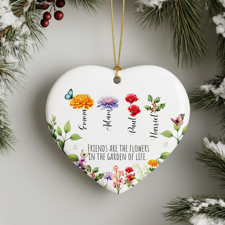 A heart-shaped ornament with a floral design and the names of four friends, each represented by a different flower. The ornament is hanging from a string, and there is a text message below it that reads &quot;Friends are the flowers in the garden of life&quot;.