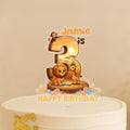 Custom jungle animal cake topper showing number 3 with lion, giraffe and monkey on African sunset landscape, personalised with name Jamie, on white birthday cakeRetry