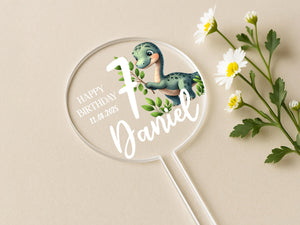 a birthday cake topper with a dinosaur on it