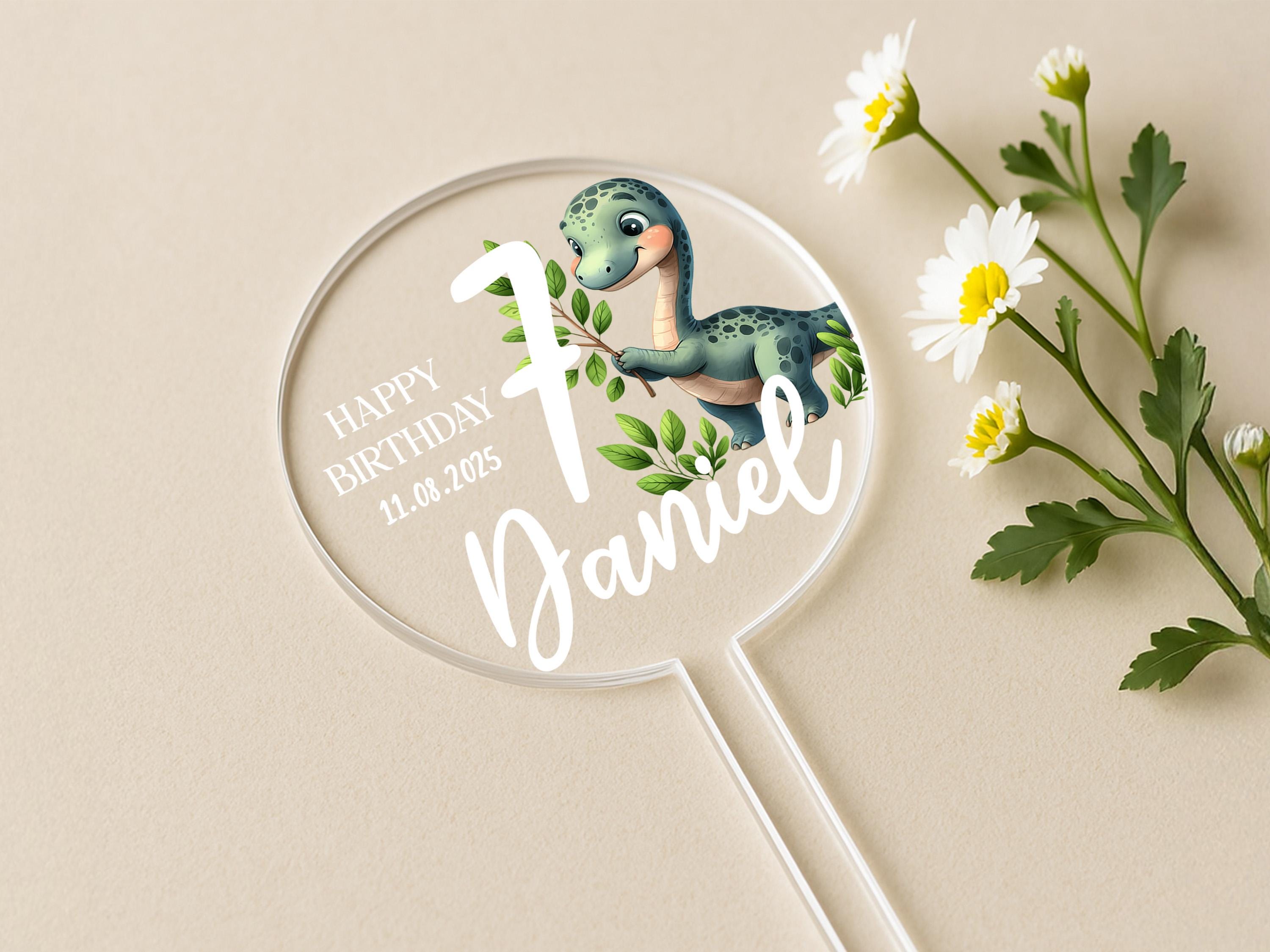 a birthday cake topper with a dinosaur on it