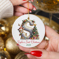 Personalised reindeer first Christmas ornament featuring letter S with cute reindeer wearing Santa hat, Christmas tree, presents and custom name Sophie's First Christmas 2025 held in hands