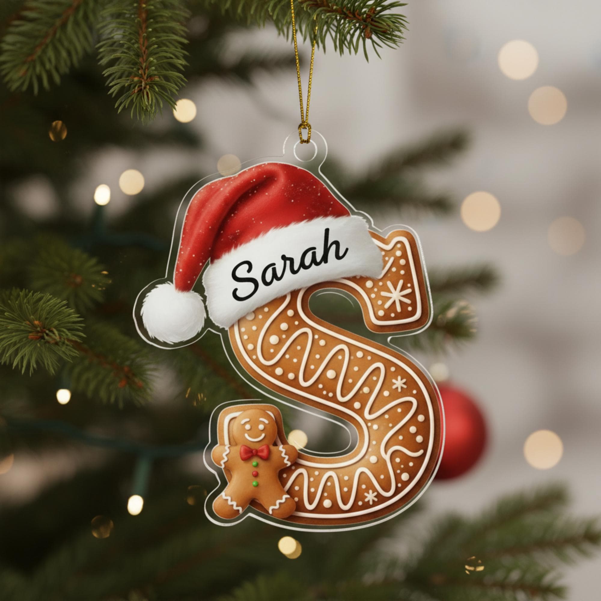 A Christmas ornament shaped like the letter 'S' with a gingerbread man figure wearing a Santa hat.