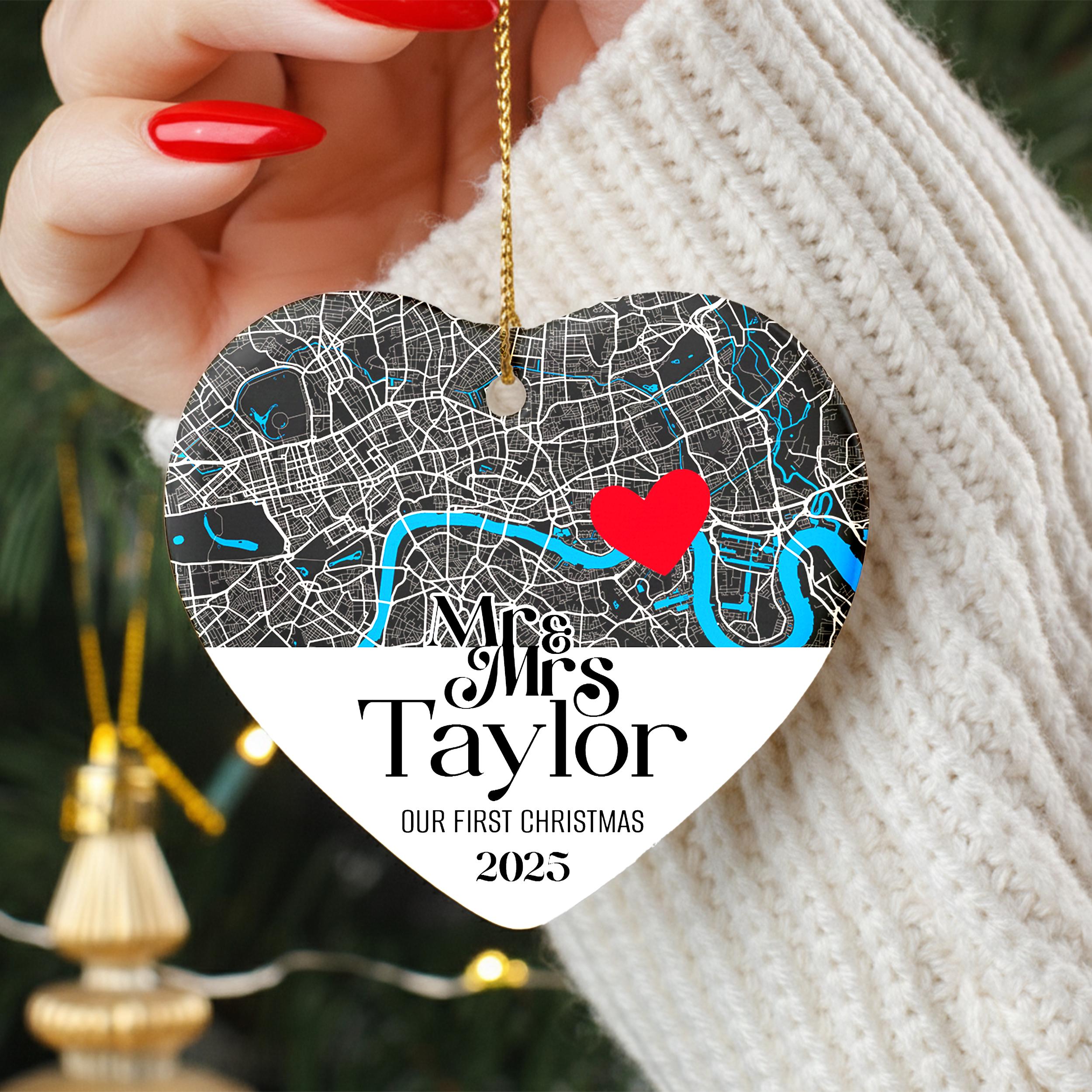 A person's hand holding a heart-shaped ornament with a map of London and a red heart symbol.