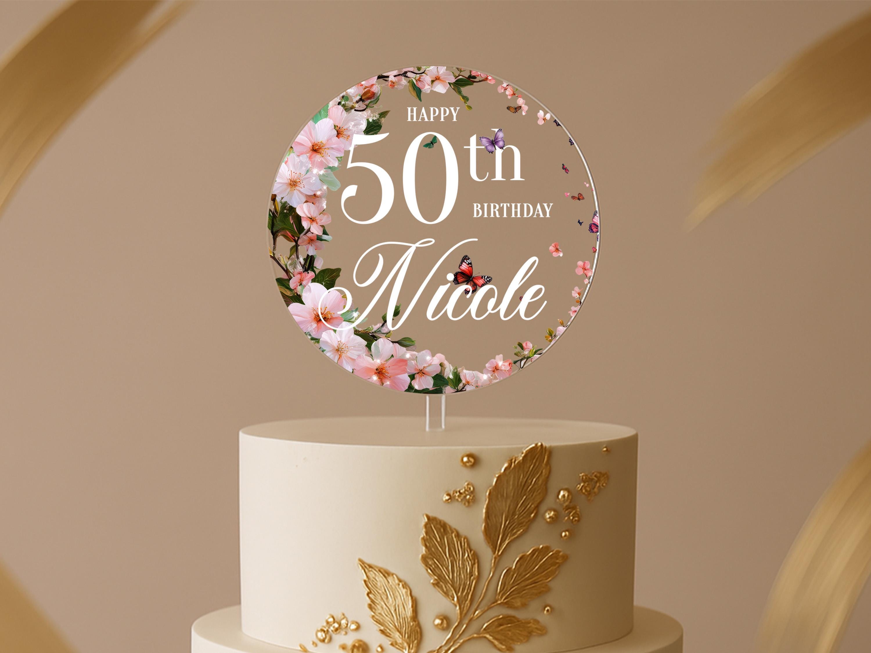 a white and gold cake with a 50th birthday cake topper