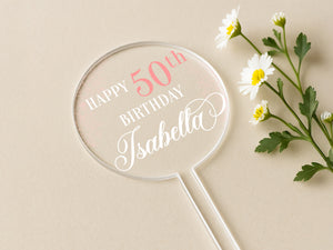 a birthday cake topper sitting next to a flower