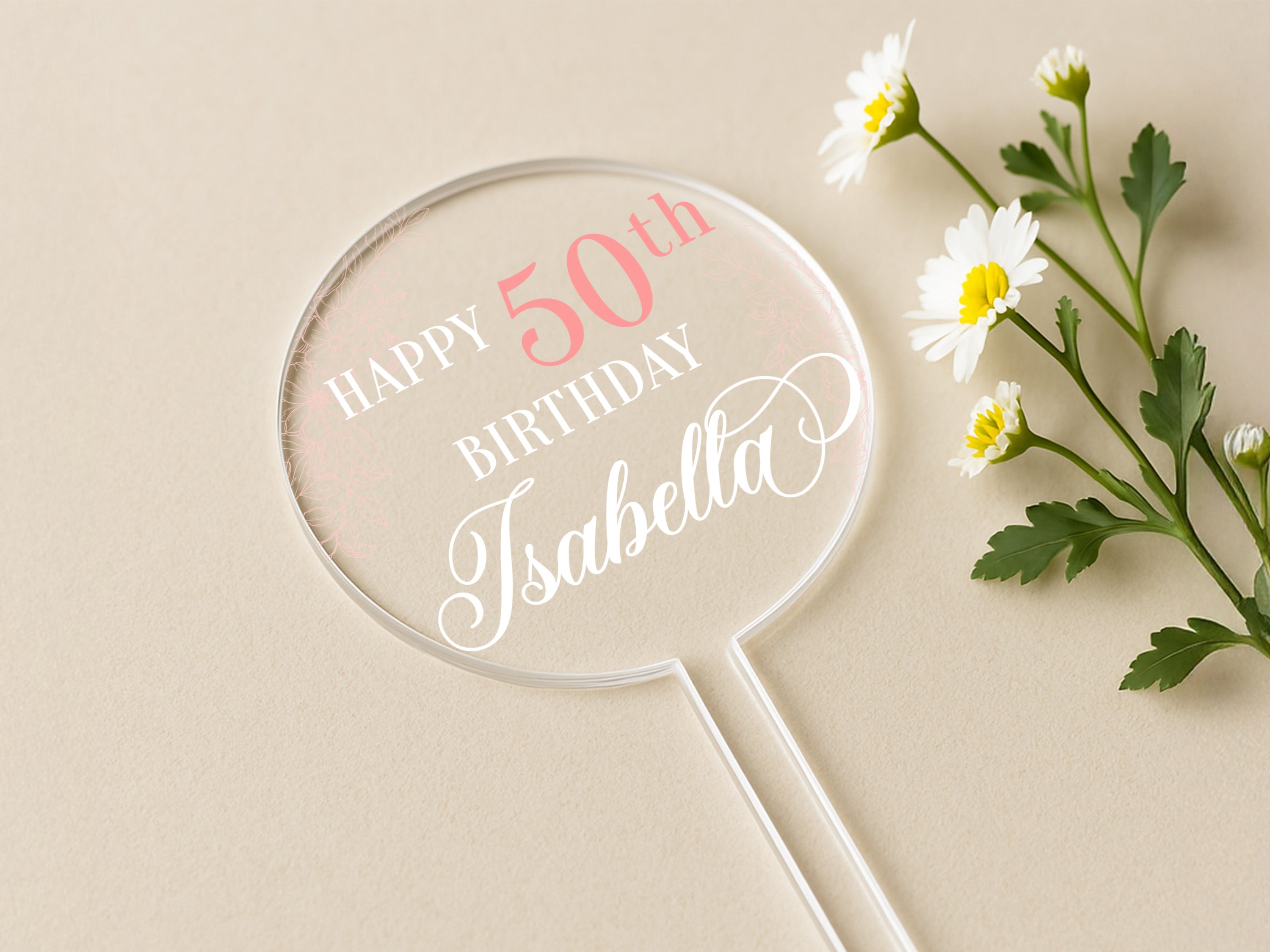 a birthday cake topper sitting next to a flower