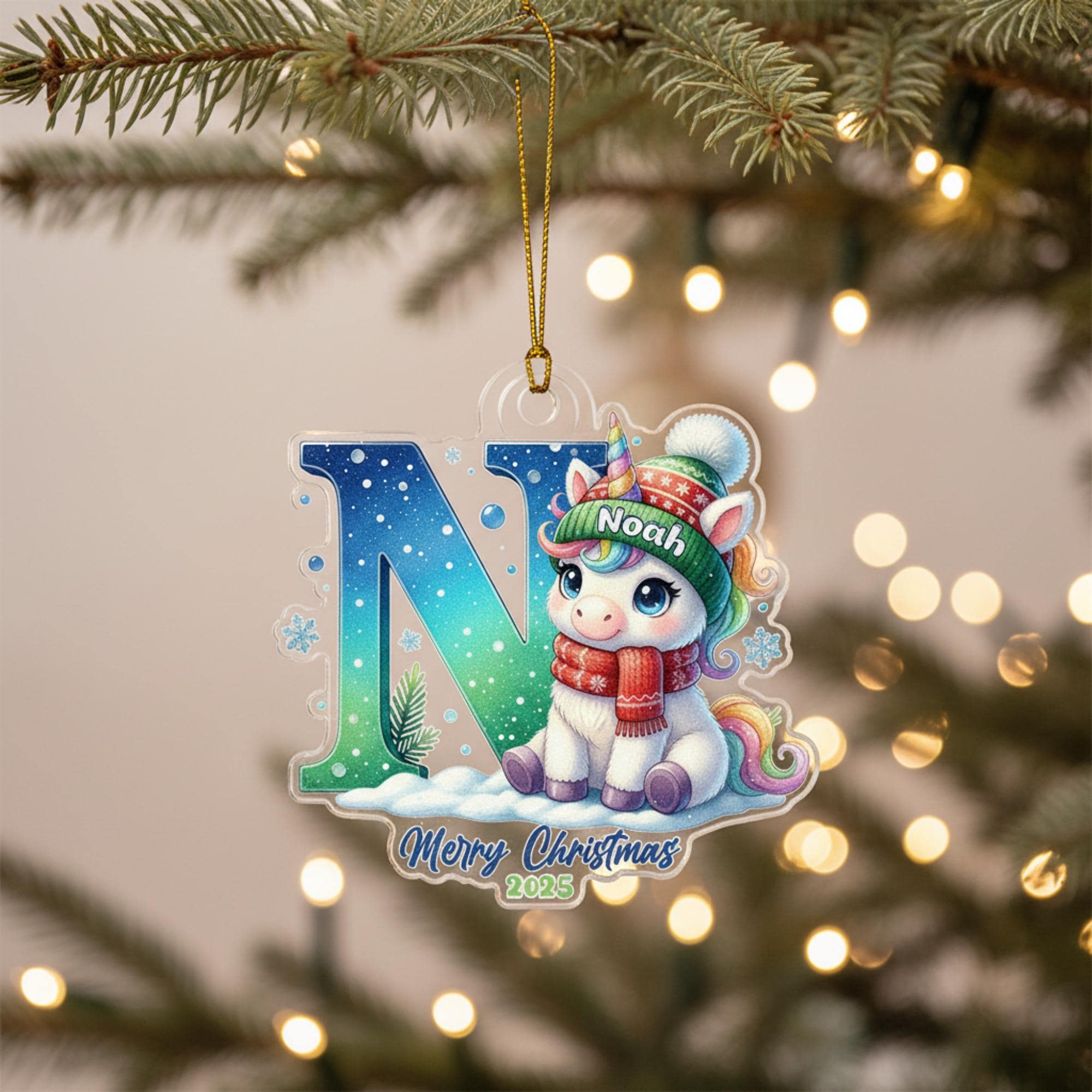 A clear ornament with a cartoon unicorn wearing a red scarf and a green hat, sitting on a snowy surface, with the letter "N" and the text "Merry Christmas 2020" below it.
