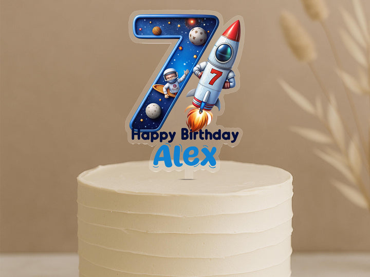 Custom astronaut space cake topper featuring number 7 with space explorer, rocket, moon and stars, personalised name Alex on celebration cake