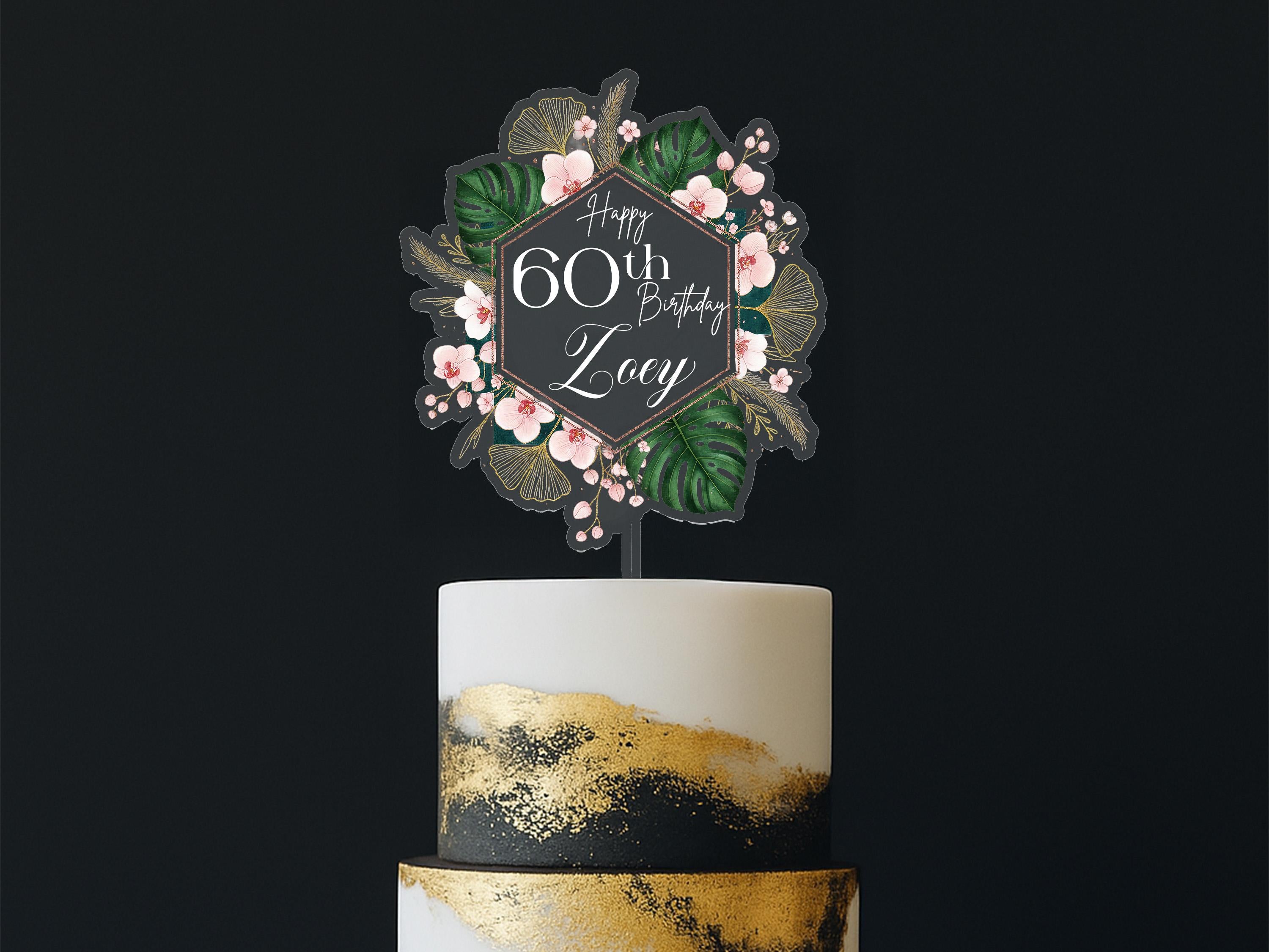 A birthday cake with a floral topper that says "Happy 60th Birthday Lizzy".