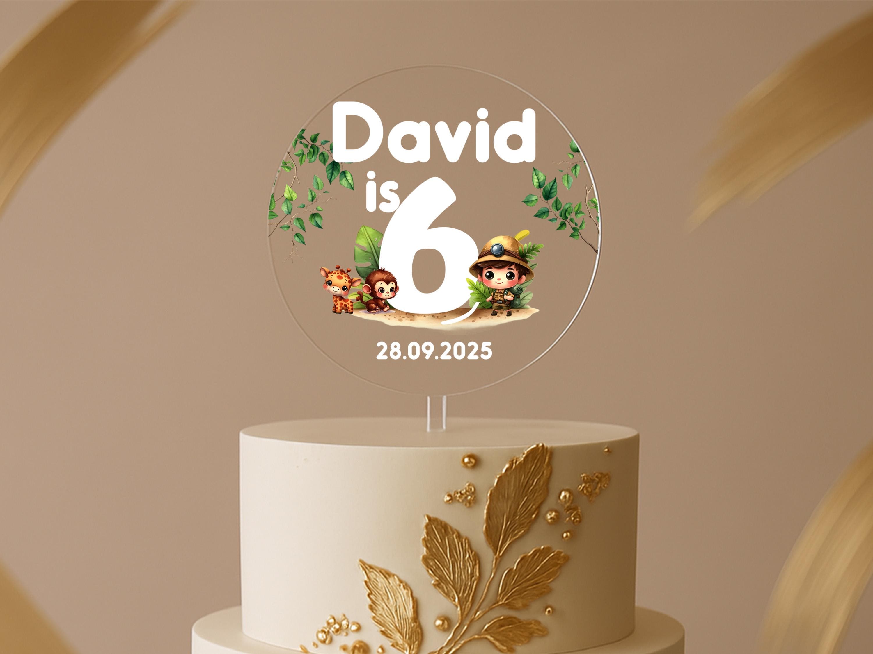 a white cake with a gold leaf decoration on top