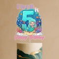 A birthday cake topper featuring a mermaid character and the number 5, with the text "Hannah is 5" and "Happy Birthday" written below.