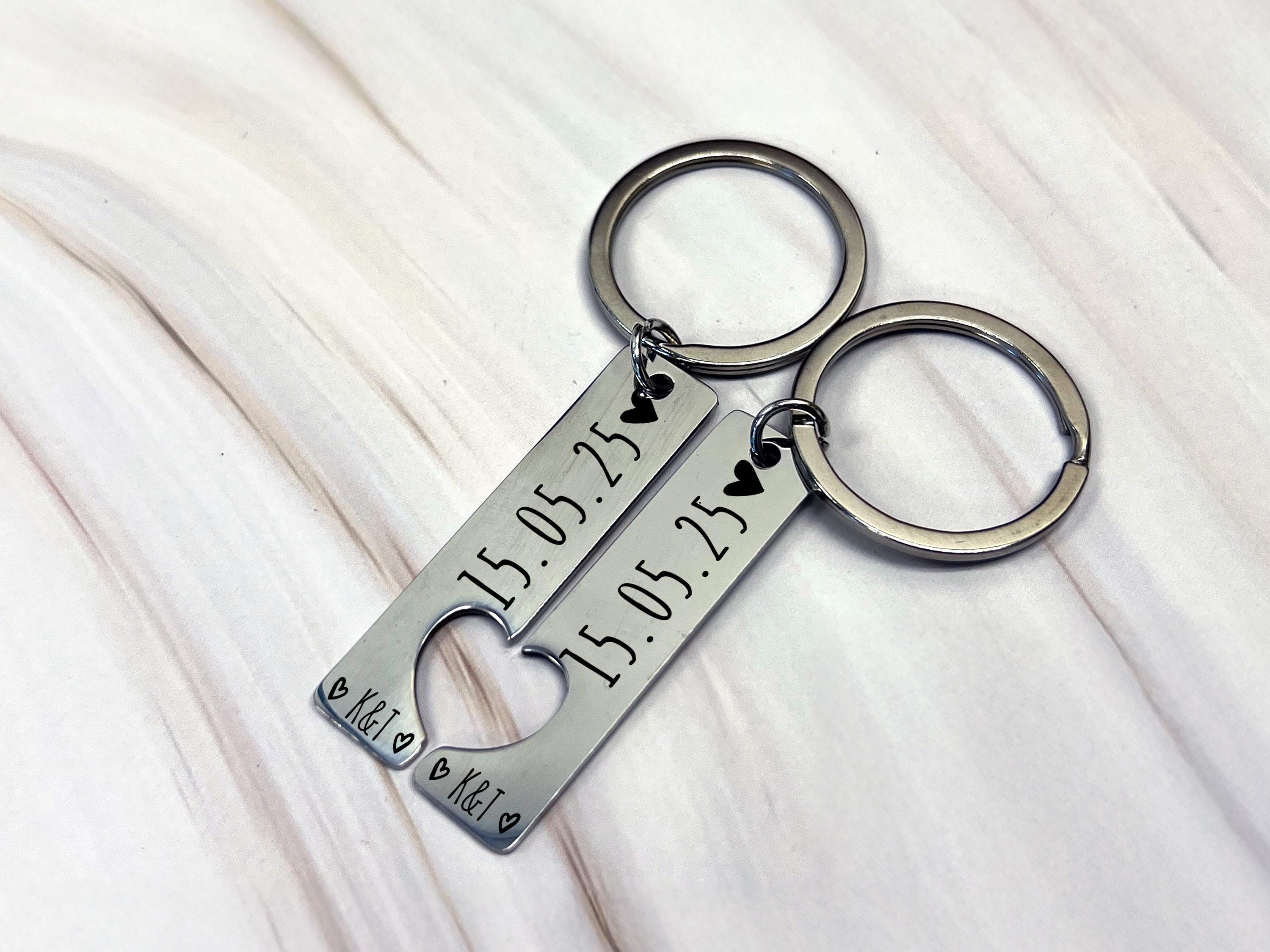 Close-up of engraved keyring details, custom date and initials, high-quality stainless steel, perfect gift for couples.