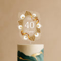 Personalised gold and white acrylic cake topper with calla lilies and ribbon reading “Happy 40 Megan” on green-gold cake
