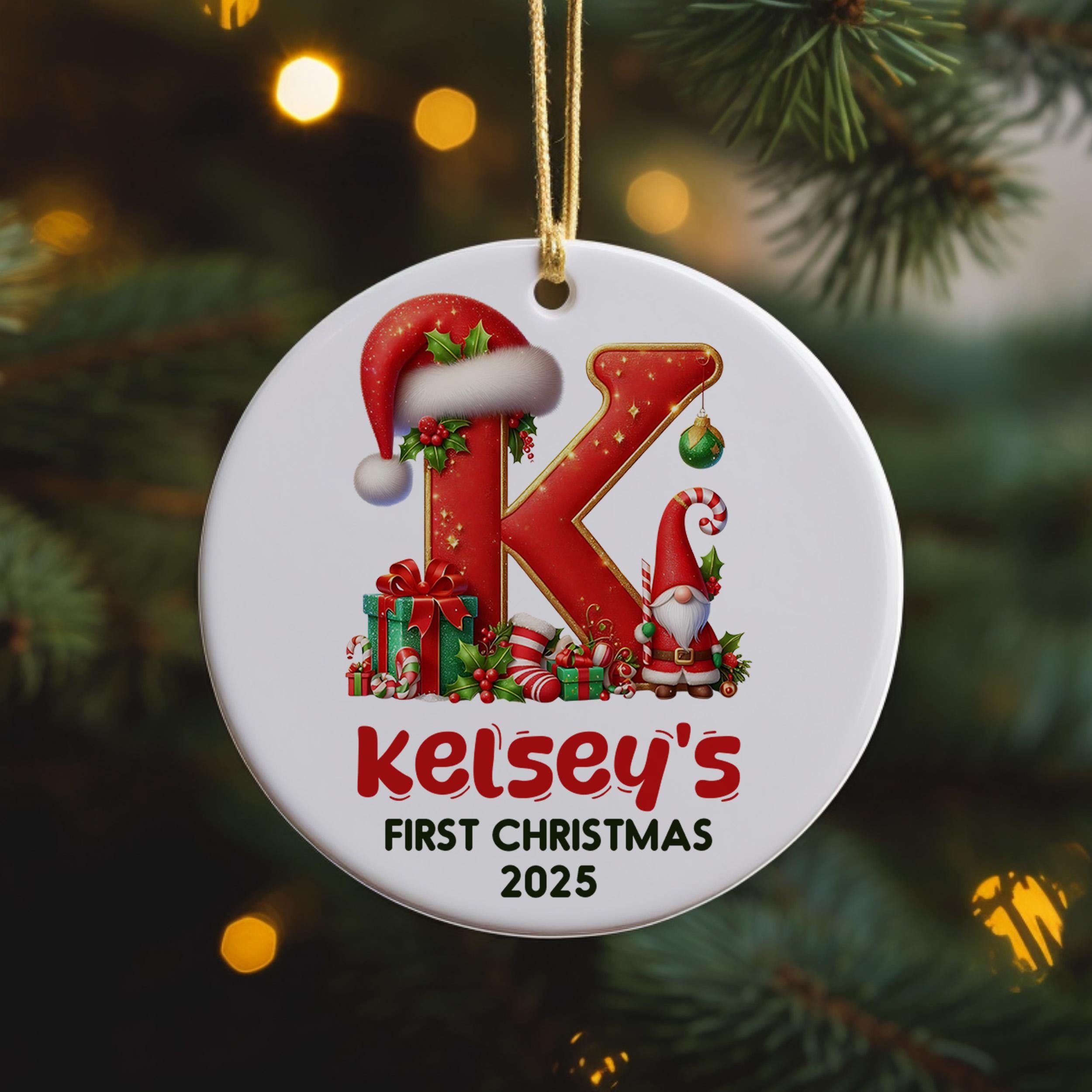 A white ornament with a red letter "K" and various Christmas-themed decorations, including a Santa hat, presents, and a gnome, hanging on a Christmas tree.