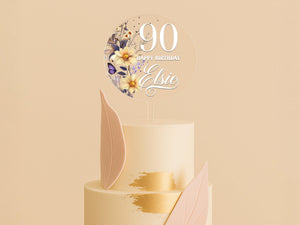 a three tiered cake with a white frosting and gold decoration