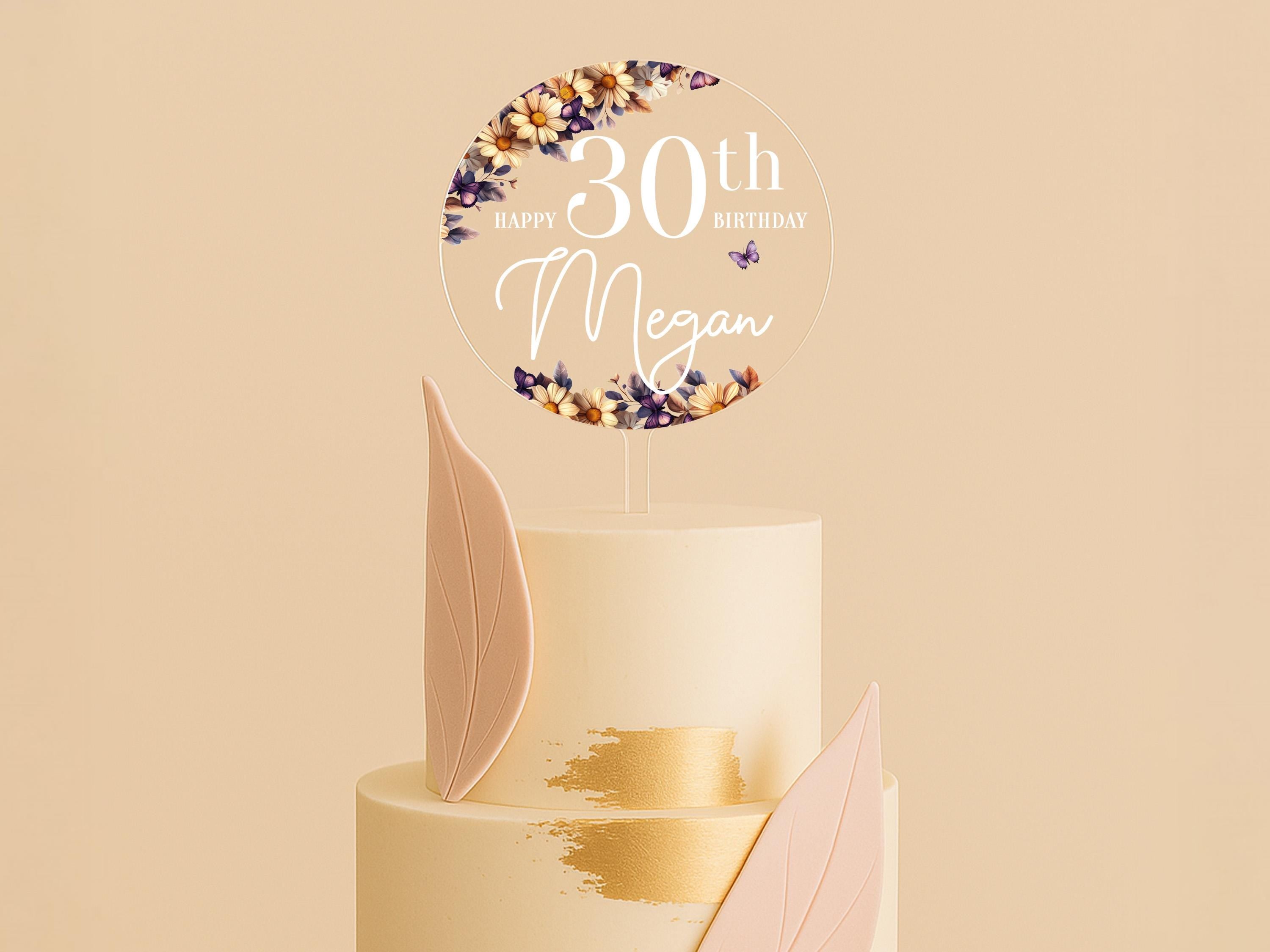 a white cake with a gold leaf decoration on top of it