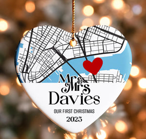 A heart-shaped ornament with a map of a city and a red heart symbol, along with the text "Mr & Mrs Davies" and "OUR FIRST CHRISTMAS 2025".