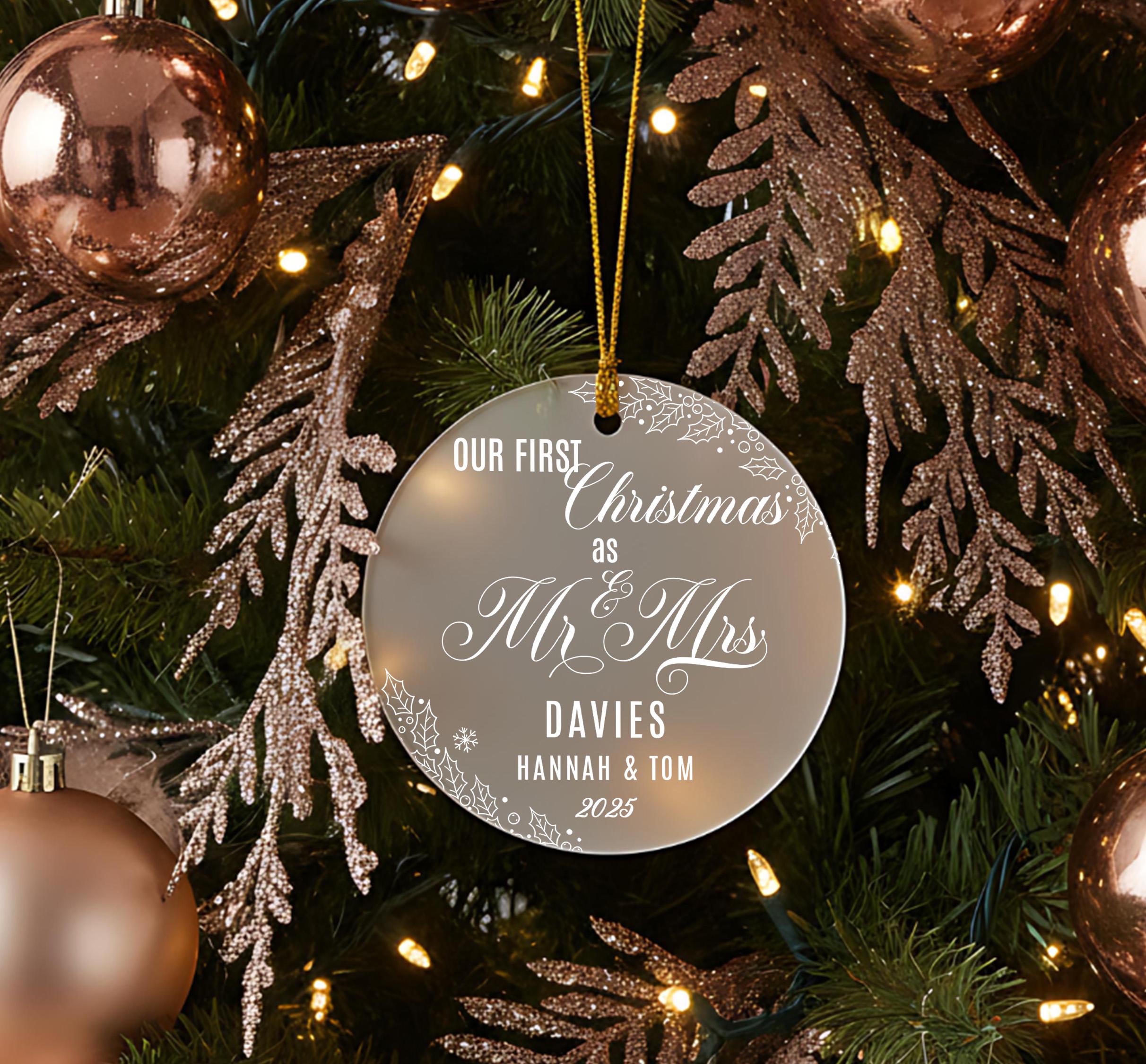 A Christmas tree decorated with ornaments, including a round ornament that says "OUR FIRST CHRISTMAS AS Mr & Mrs DAVIES Hannah & Tom 2015".