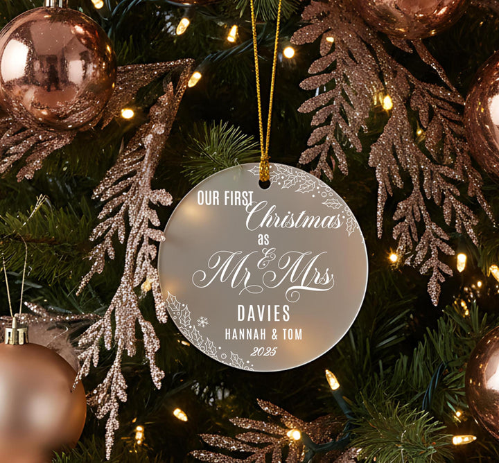 A Christmas tree decorated with ornaments, including a round ornament that says &quot;OUR FIRST CHRISTMAS AS Mr & Mrs DAVIES Hannah & Tom 2015&quot;.