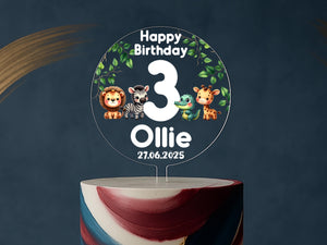Jungle-themed birthday cake adorned with custom name and age topper featuring safari animals.
