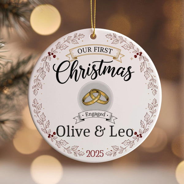 Personalised ceramic Christmas ornament featuring Our First Christmas text with wedding rings, Engaged banner, holly wreath border and custom names Olive & Leo 2025 on festive background