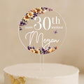 a birthday cake with a white cake topper with flowers on it