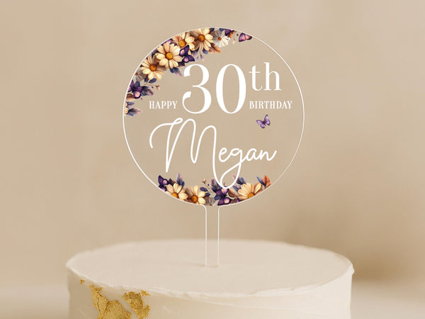 a birthday cake with a white cake topper with flowers on it