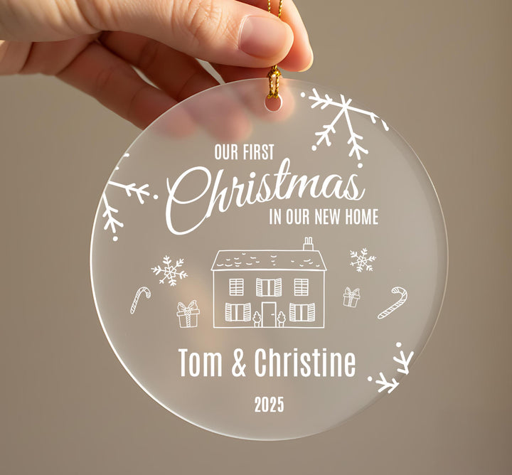 A hand holding a clear ornament with a Christmas-themed design and text.