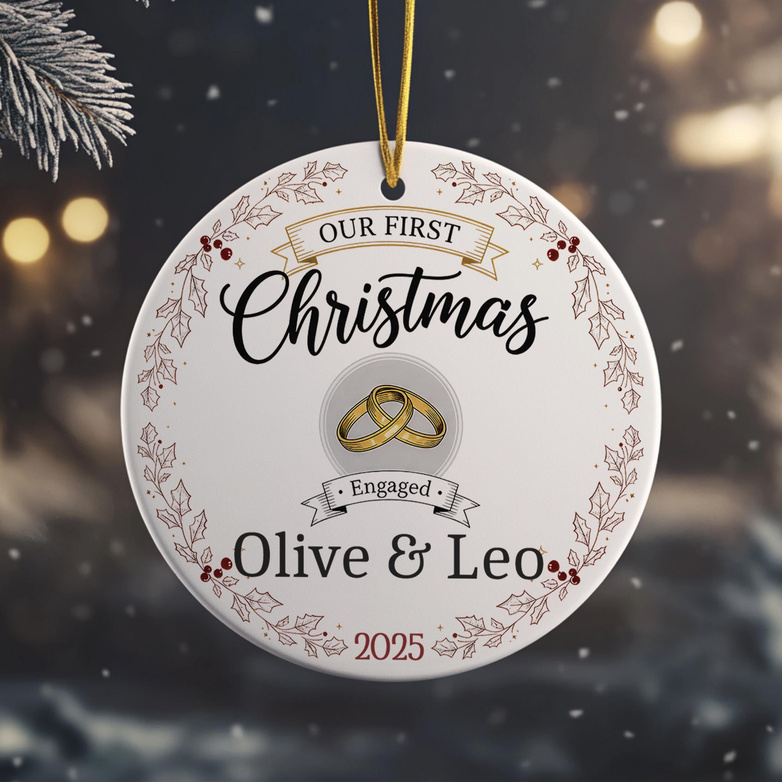 A white Christmas ornament with a gold ring and the text "Our first Christmas" and "Engaged Olive & Leo" printed on it.