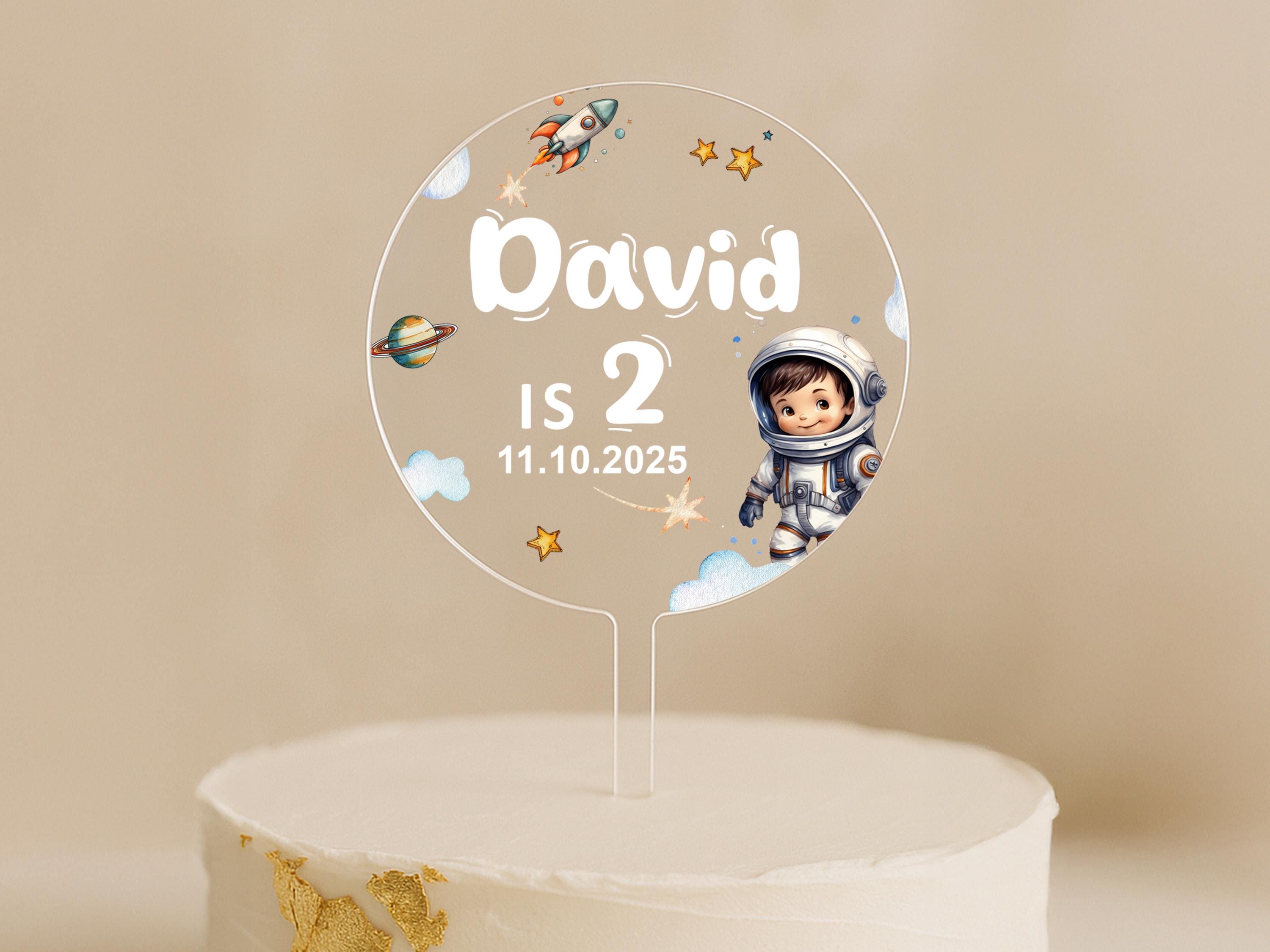 a cake with a cake topper that says david is 2