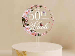 a birthday cake with a white frosting and pink flowersRound 50th birthday cake topper with pink floral ring and butterflies