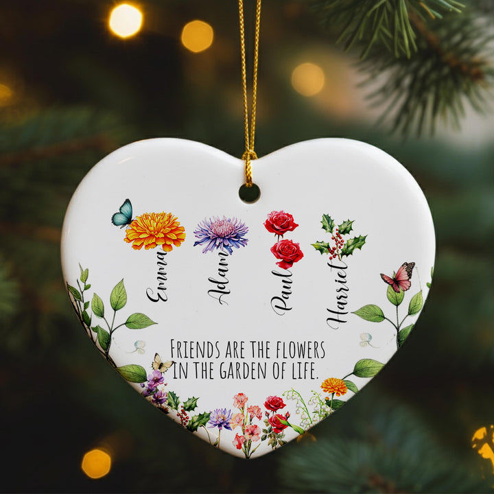 A heart-shaped ornament with a floral design and the names of four friends, each with a different flower. The ornament is hanging on a tree branch, and there is a quote about friends being the flowers in the garden of life.