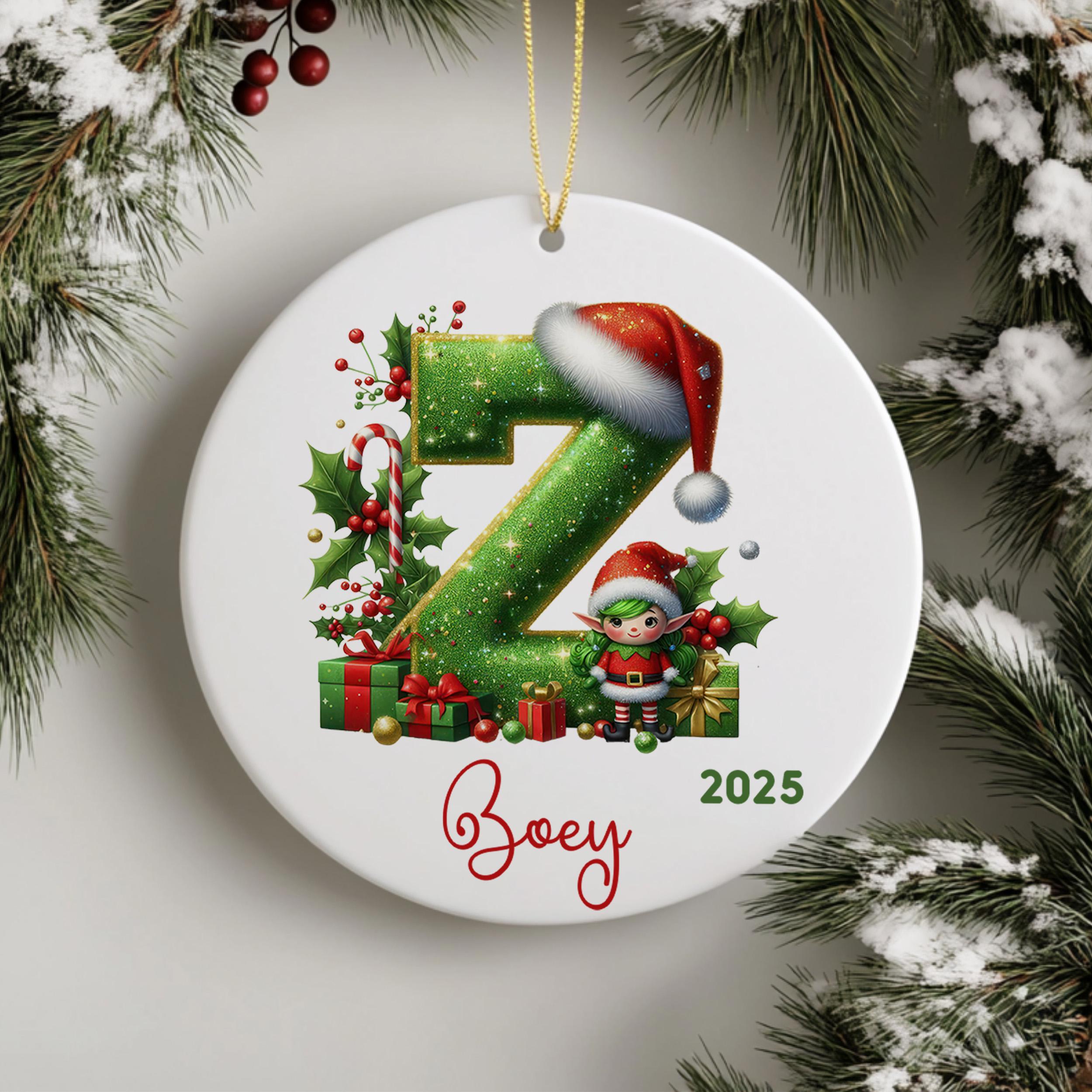 A white ornament with a green letter "Z" and a small elf wearing a Santa hat, surrounded by Christmas decorations such as presents and holly leaves.