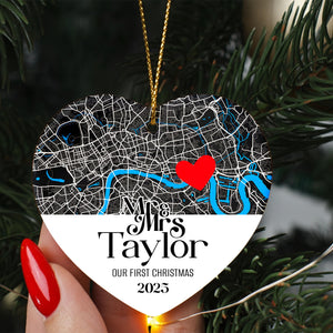 A heart-shaped ornament with a map of London and a red heart symbol, hanging on a Christmas tree.
