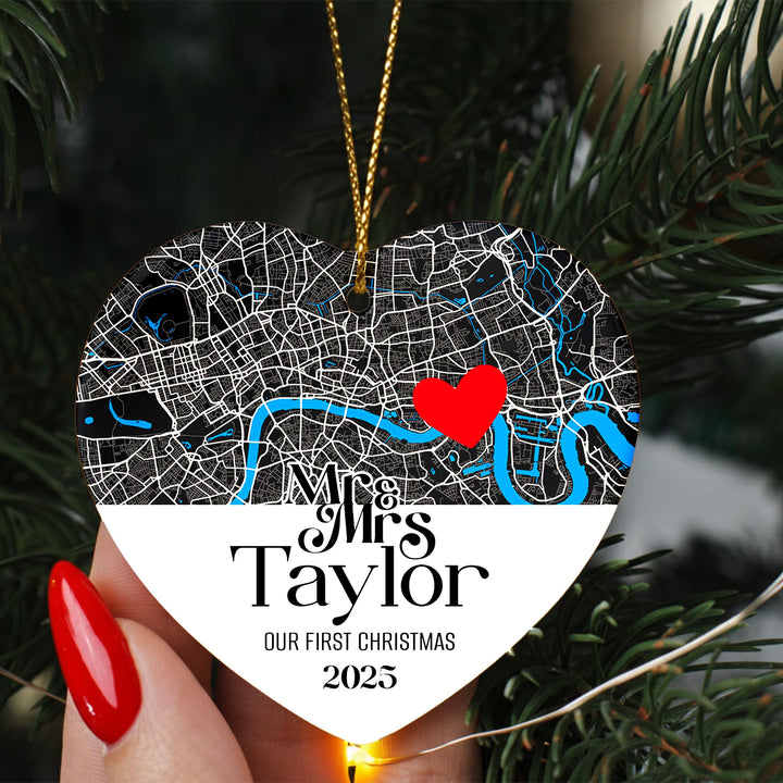A heart-shaped ornament with a map of London and a red heart symbol, hanging on a Christmas tree.